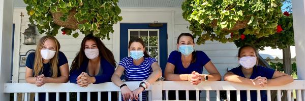 The photo contest will help document people's COVID-smart behaviors including wearing face masks as the wait staff at the Blue Paddle Bistro in South Hero, Vermont do when serving guests. Photo: Lake Champlain Islands Economic Development Corporation Wait staff on porch wearing face masks